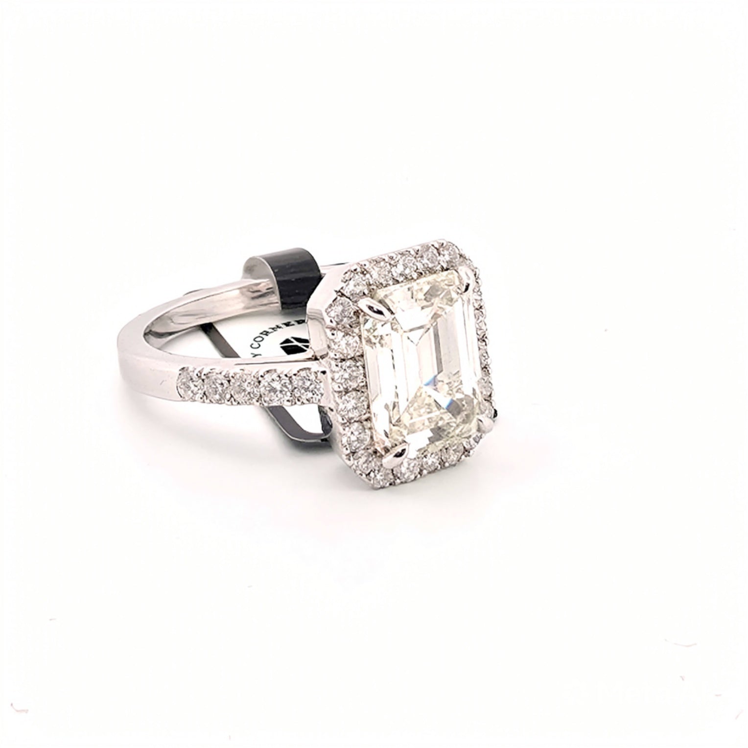 Anello in oro bianco 18kt con diamante smeraldo al centro e diamanti a contorno e sul gambo